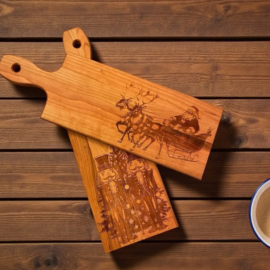 Two cherry serving boards engraved with holiday scenes