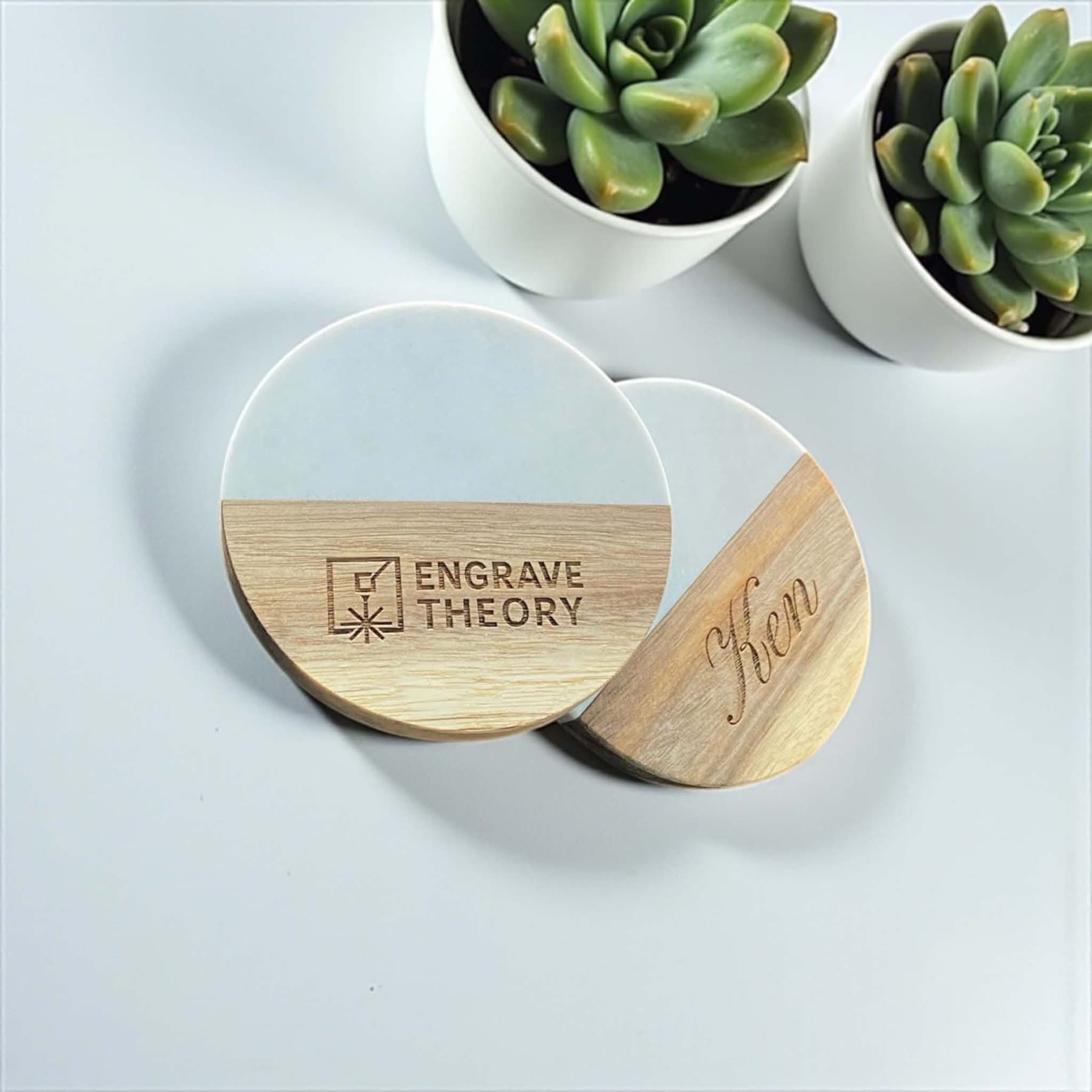 Marble and wood coasters engraved with a name and a logo